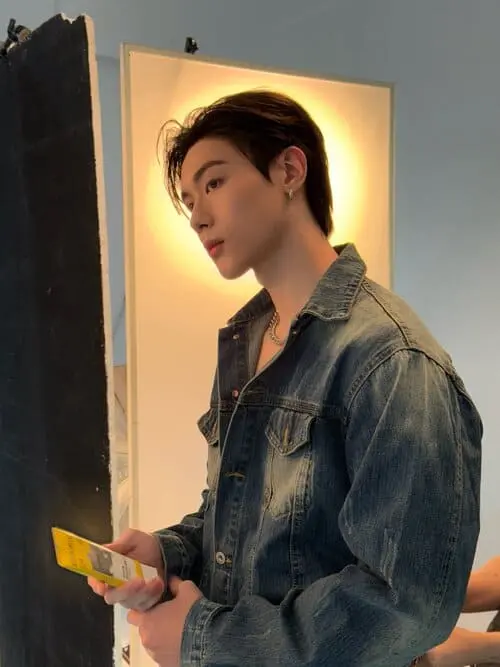 toptap-jarukit-kaewmoonrueang-hinh-anh-5 Toptap Jarukit Kaewmoonrueang mặc áo khoác denim, cầm điện thoại đứng hậu trường ánh đèn vàng