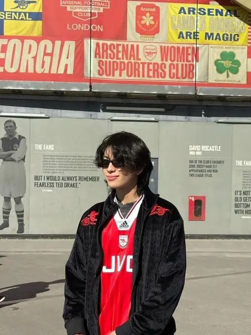 tytan-teepprasan-hinh-anh-5 Tytan Teepprasan đeo kính râm mặc áo khoác đen đứng trước sân vận động Arsenal